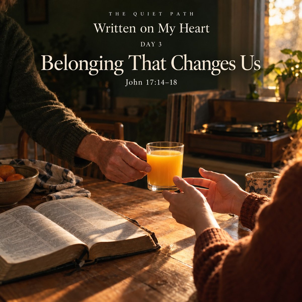 An older man hands a glass of orange juice across a sunlit kitchen table to a younger person, an open Bible on the table and a record player by the window. Text: THE QUIET PATH · Written on My Heart · Day 3 · Belonging That Changes Us · John 17:14–18